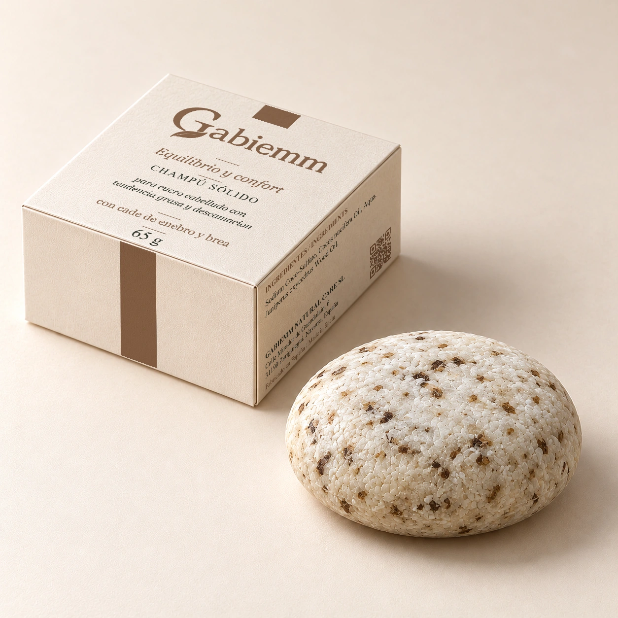 Mockup digital de la caja Equilibrio y confort de Gabiemm, de 65 g, junto a su pastilla de champú sólido. Se conserva el diseño original de tapa y caras visibles; pastilla de forma abombada y bordes redondeados.